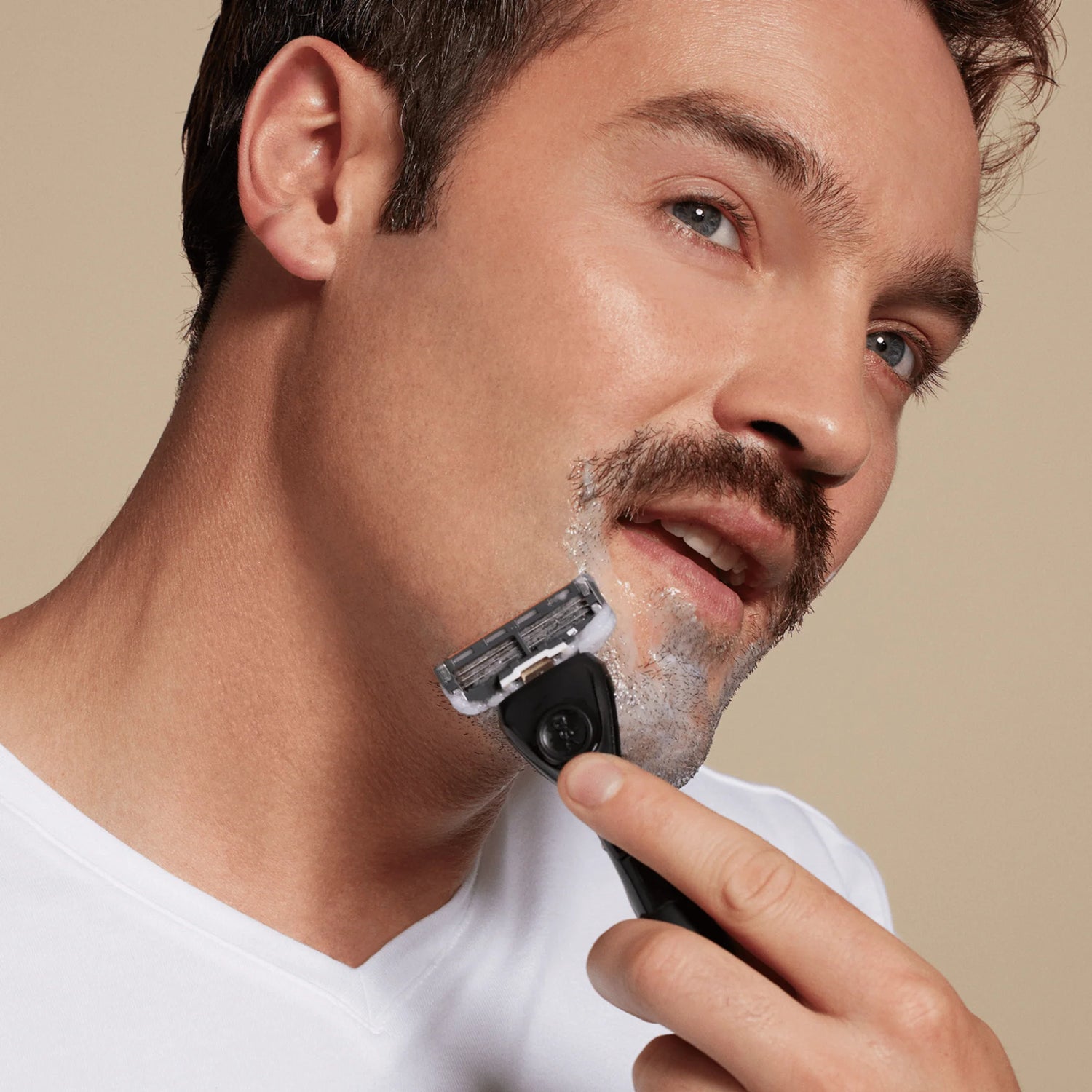 Man shaving with razor.